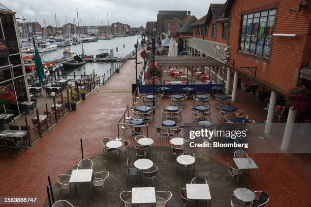 Empty restaurant tables along the waterfront at Sovereign Harbour in Eastbourne, UK, on Saturday, Aug. 5, 2023. A jobs boom in Britain's seaside...