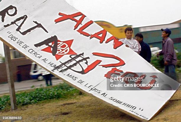 Team of workers dismantle a campaign poster for presidential candidate Alan Garcia, an ex-president of Peru who recently lost the runoff election to...