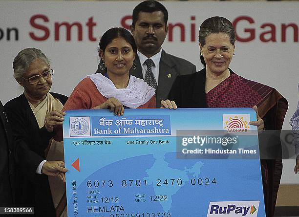 Chairperson Sonia Gandhi and Delhi Chief Minister Sheila Dikshit giving away an Aadhar enabled card during the launch of the Delhi Annshree Yojana on...