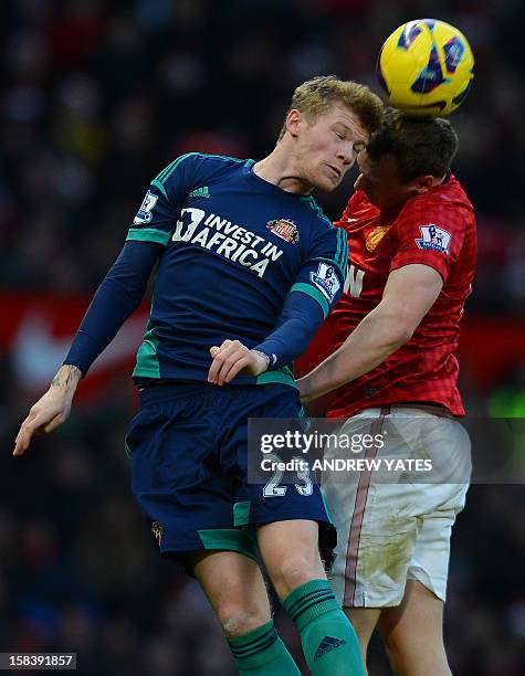 Sunderland's Irish midfielder James McClean challenges Manchester United's English defender Phil Jones for the ball in the air during the English...