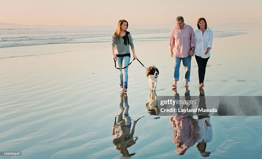 Beach walking family with dog