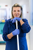 Portrait of happy professional female cleaner smiling in office