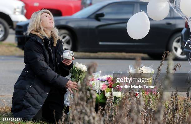 Andrea Jaeger places flowers and a candle at a makeshift memorial outside a firehouse which was used as a staging area for families following the...