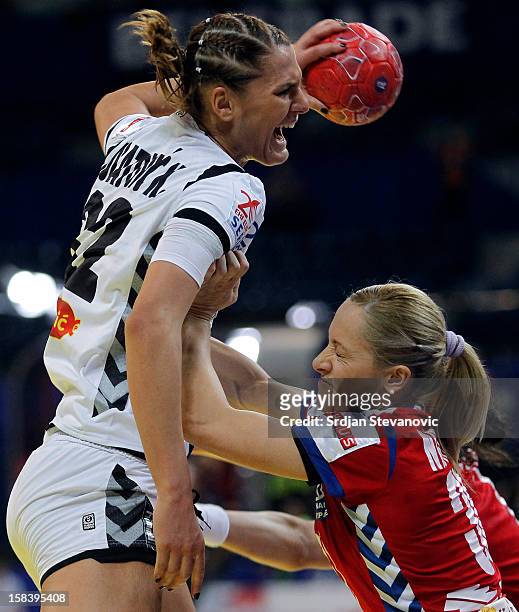 Katarina Bulatovic of Montenegro is challenged by Jelena Nisavic of Serbia during the Women's European Handball Championship 2012 semifinal match...