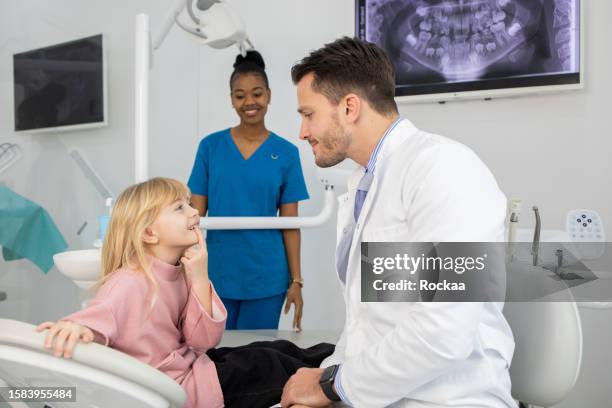 bambina con la sua madre all'esame del dentista - dentista bambini foto e immagini stock