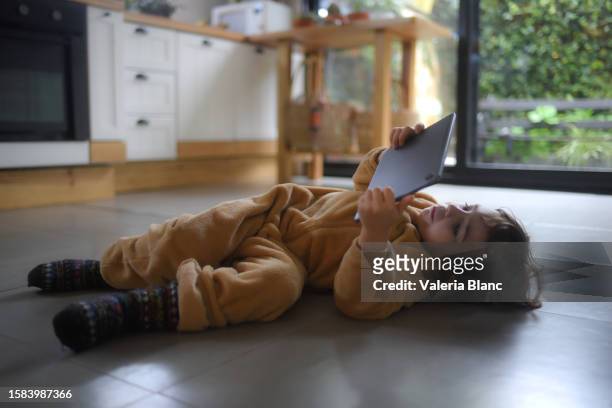 boy playing with tablet on kitchen floor - ipad blanc stock pictures, royalty-free photos & images