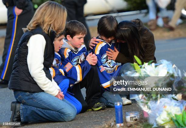 Children and their family pay tribute to the victims of an elementary school shooting in Newtown, Connecticut, on December 15, 2012. A young gunman...