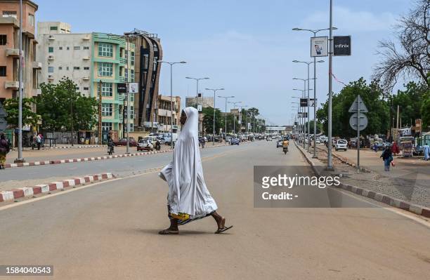 Woman walks across a road in Niamey on August 8, 2023. Despite the restrictions on freedoms, the coup in Niger is welcomed by many inhabitants of the...