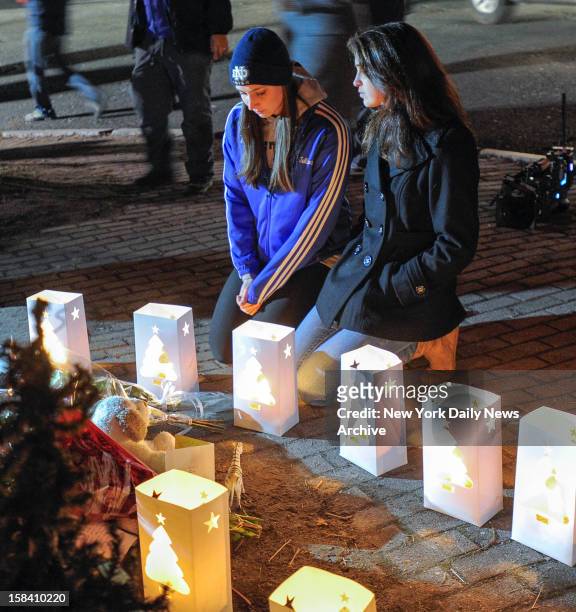 Girls kneel during candle light vigil following shooting at Sandy Hook Elementary school where Adam Lanza opened fire inside school killing 27...