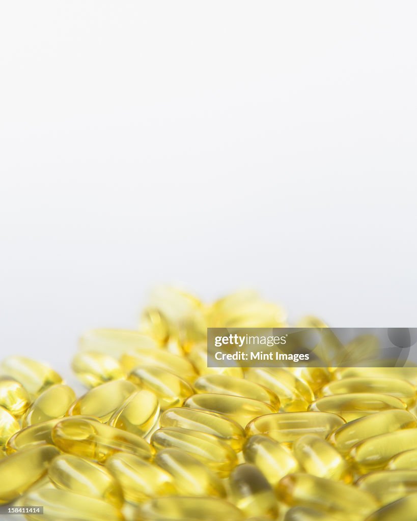 Fish oil providing Omega-3, in soft gel supplement capsules. An essential fatty acid and health supplement product. 