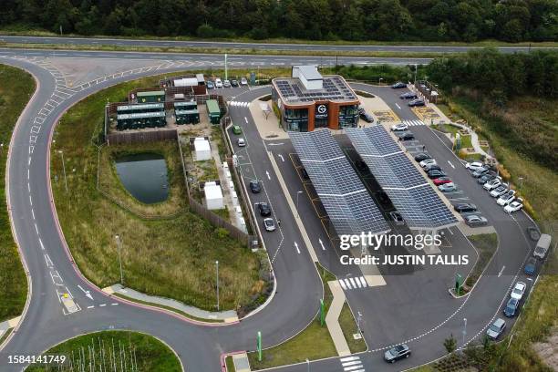 An aerial photograph taken on August 8, 2023 shows solar panels on the roof of a Gridserve E-charging station for all-electric car, near Braintree,...