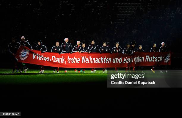 The players of Muenchen show a banner to wish merry christmas and a happy new year to their supporters after the Bundesliga match between FC Bayern...