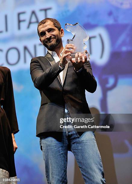 Actor Amr Waked with the Muhr Arab Feature Best Actor award on stage during the Closing Ceremony on day eight of the 9th Annual Dubai International...