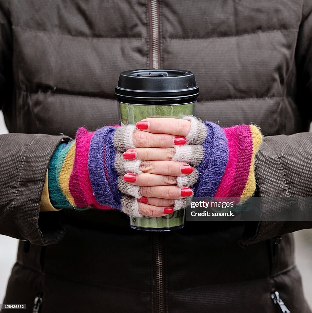 Colorful hands holding carry cup.