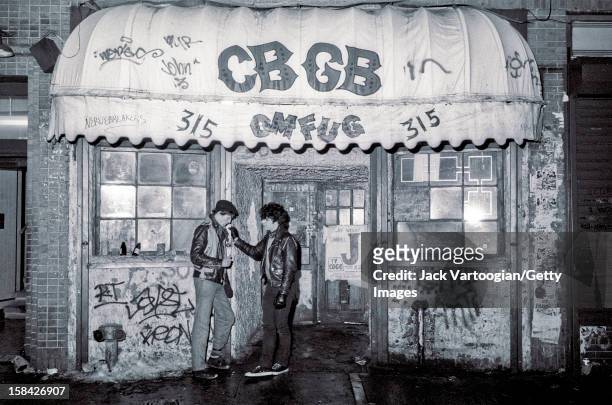 Two unidentified young men in leather jackets stand outside CBGB on Valentine's Day, New York, New York, February 14, 1983.