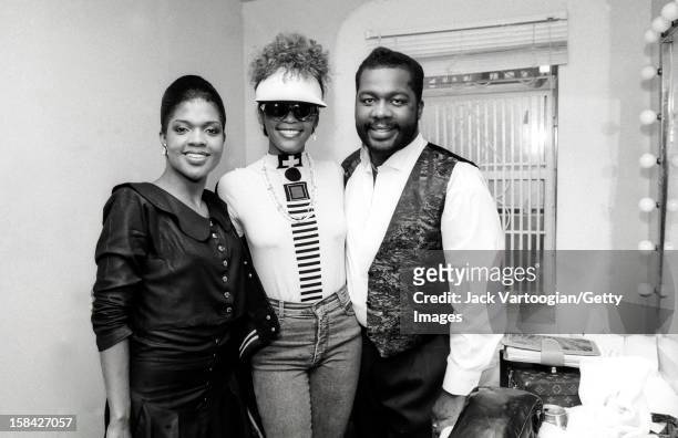 American singer and actress Whitney Houston poses with sibling Gospel singers Cece and Be Be Winans backstage after a Winans concert at Harlem's...