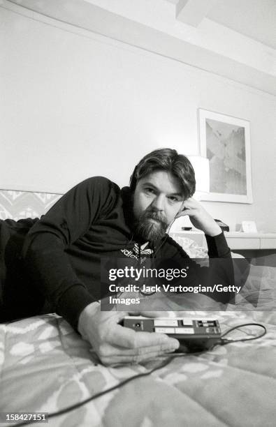 Portrait of American musician Bob Seger as he listen to a portable cassette player on the bed in his hotel room, New York, New York, December 13,...