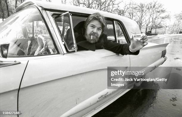 Portrait of American musician Bob Seger as leans out of the window of a car in Central Park, New York, New York, December 13, 1982. He holds a...