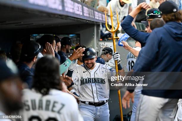 Cal Raleigh of the Seattle Mariners celebrates with teammates in the dugout after hitting a solo home run during the seventh inning against the...