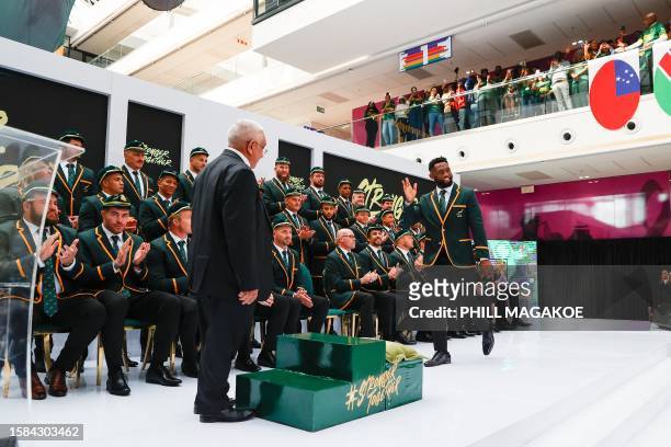 South Africa's flanker Siya Kolisi waves as he walks on stage during the South Africa Rugby World Cup squad announcement in Johannesburg on August 8,...