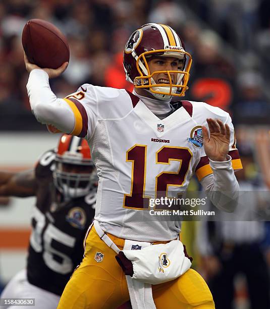 Quarterback Kirk Cousins of the Washington Redskins throws a pass as he is pressured by defensive lineman Juqua Parker of the Cleveland Browns at...