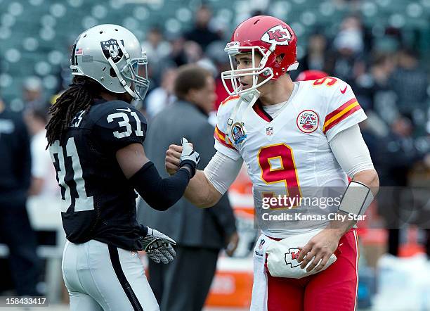 Kansas City Chiefs quarterback Brady Quinn and Oakland Raiders defensive back Coye Francies meet during warmups before the game at O.co Coliseum in...