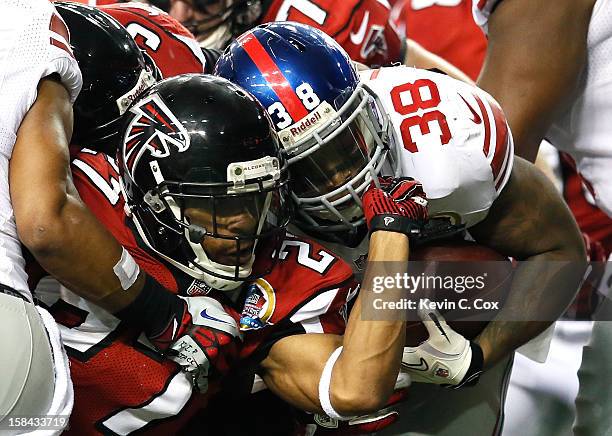 Robert McClain of the Atlanta Falcons grabs the facemask of Kregg Lumpkin of the New York Giants on a tackle at Georgia Dome on December 16, 2012 in...