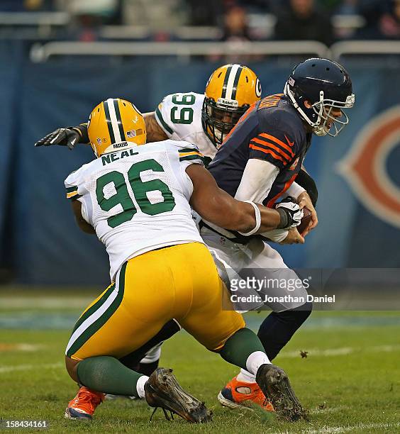 Jay Cutler of the Chicago Bears is sacked by Mike Neal and Jerel Worthy of the Green Bay Packers at Soldier Field on December 16, 2012 in Chicago,...