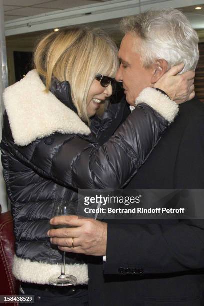 Singer Michel Sardou shares a light moment with actress Mireille Darc in his dressing room following his show at Palais Omnisports de Bercy on...