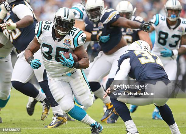 Running back Mke Tolbert of the Carolina Panthers carries the ball against safety Eric Weddle of the San Diego Chargers at Qualcomm Stadium on...