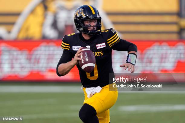 Taylor Powell of the Hamilton Tiger-Cats rolls out to pass against the Toronto Argonauts at Tim Hortons Field on July 21, 2023 in Hamilton, Canada.