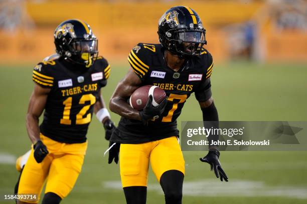 Tim White follows Terry Godwin II of the Hamilton Tiger-Cats after a pass reception against the Toronto Argonauts at Tim Hortons Field on July 21,...