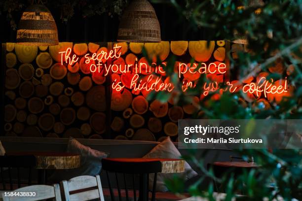 neon sign on wall. cozy interior of cafe. - letrero de neón fotografías e imágenes de stock