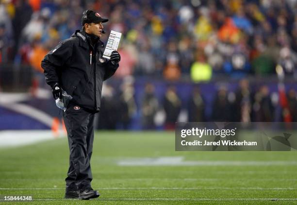 Head coach Jim Harbaugh of the San Francisco 49ers stands on the field during the game against the New England Patriots at Gillette Stadium on...