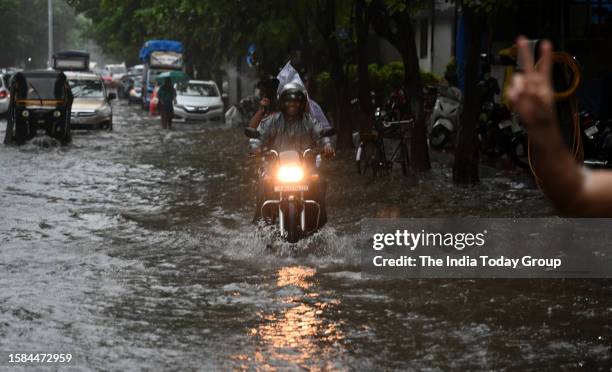 Mumbai, India – July 27: Vehicles move through a waterlogged road amid rainfall, in Mumbai, Maharashtra on July 27, 2023.