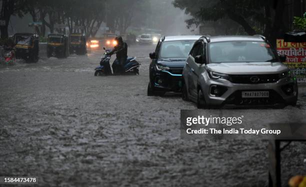 Mumbai, India – July 27: Vehicles move through a waterlogged road amid rainfall, in Mumbai, Maharashtra on July 27, 2023.
