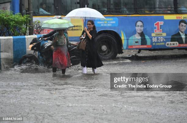 Mumbai, India – July 27: Commuters holding umbrellas move through a heavily waterlogged road amid rainfall in Mumbai, Maharashtra on July 27, 2023.