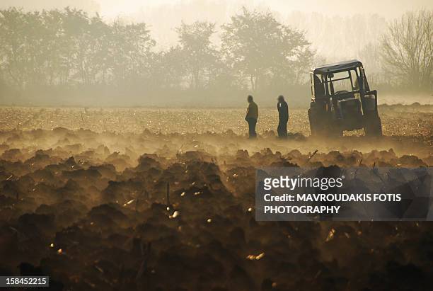 farmers on a freshly plowed field - ploughed field stock pictures, royalty-free photos & images