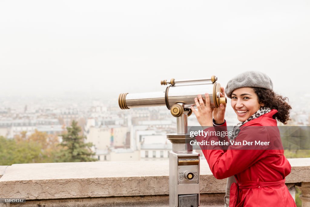 Tourist looks at cityscape with viewfinder, Paris.