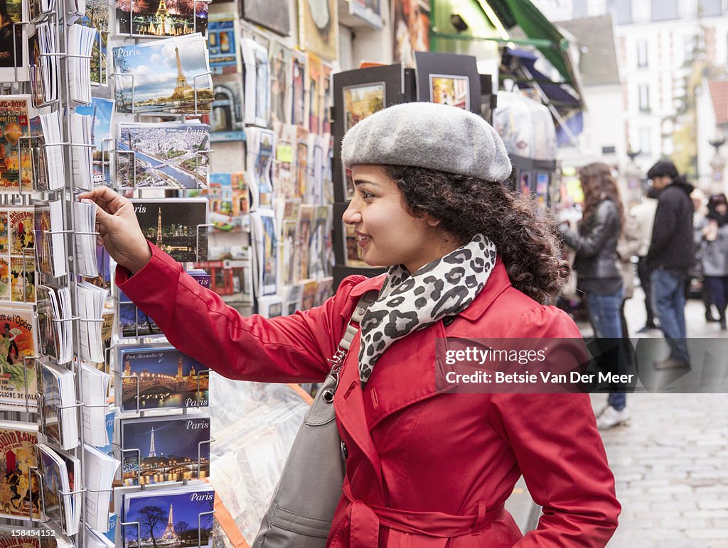 Woman looking at postcards at Montmartre, Paris.