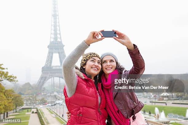 women taking photo of themselves and eiffeltower. - the two towers stock pictures, royalty-free photos & images