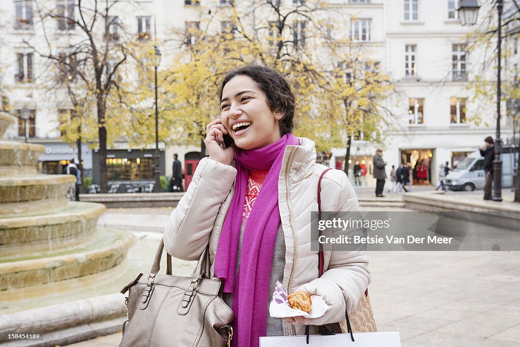 Woman on phone in shopping street, Paris.