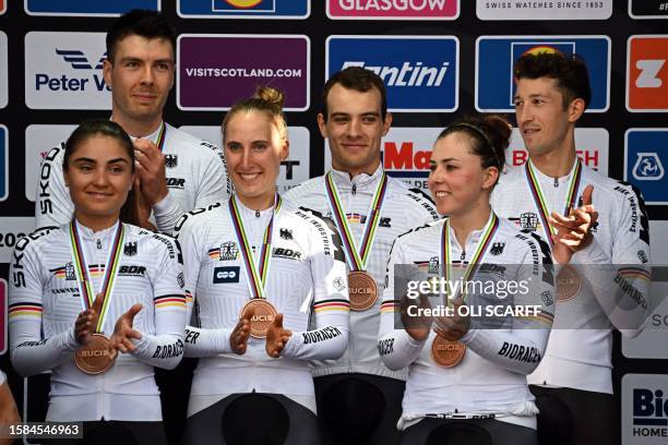 Riders from Germany celebrate with their bronze medals and cow mascots after the Team Time Trial Mixed Relay road race during the UCI Cycling World...