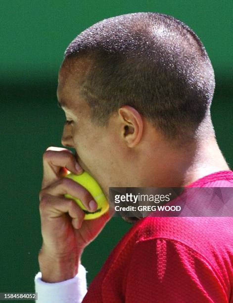 Hicham Arazi of Morocco bites into the ball during his loss to Juan Carlos Ferrero of Spain in their men's singles quarter-final match at the...