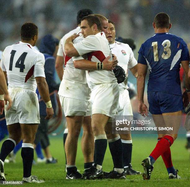 English prop Trevor Woodman hugs a teammate while English prop Phil Vickery , winger Jason Robinson and French centre Tony Marsh look on during the...