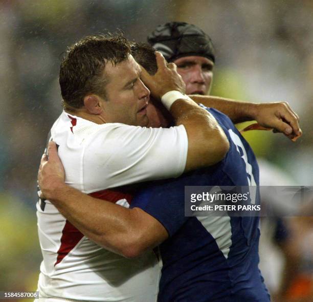 French prop Sylvain Marconnet is hugged by English prop Jason Leonard while English prop Phil Vickery looks on after the Rugby World Cup semi-final...