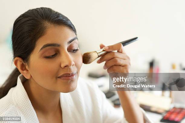 asian woman applying make up with brush. - applying makeup with brush foto e immagini stock