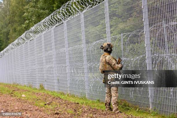 Member of the State Border Guard patrols along the fence at the Latvia/Belarus border near Krivanda, Eastern Latvia on August 8 during a vist by the...