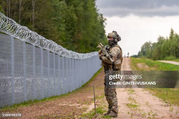 Member of the State Border Guard patrols along the fence at the Latvia/Belarus border near Krivanda, Eastern Latvia on August 8 during a vist by the...