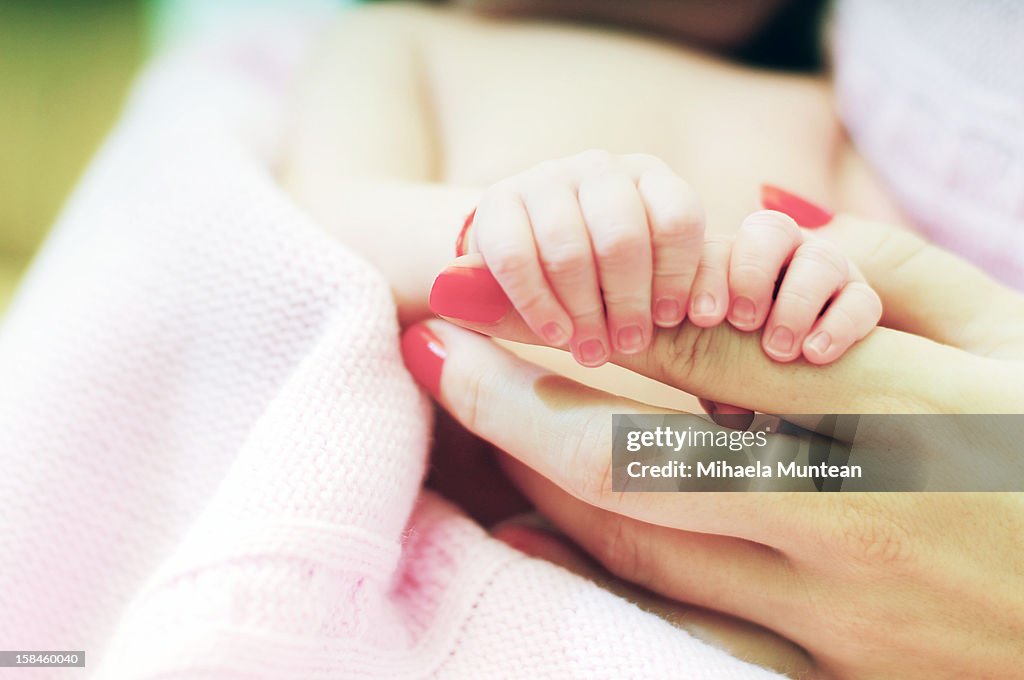 Little child holds mom's hand